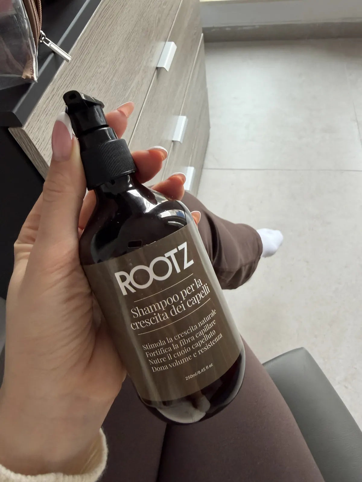 Una cliente tiene in mano il flacone ROOTZ il giorno della consegna